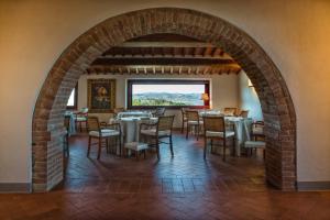 un arco en un restaurante con mesas y sillas en The Club House en Castelnuovo Berardenga