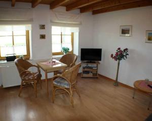 a living room with a table and chairs and a television at Rügen Fewo 287 in Kluis