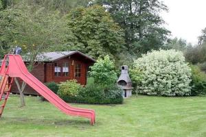 a red slide in a yard next to a house at Rügen Fewo 287 in Kluis