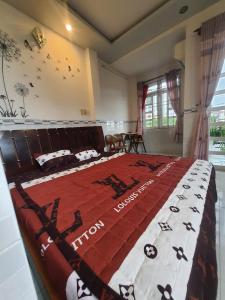 a bedroom with a large bed with a red and white blanket at NHÀ NGHỈ BẾN TÀU in Rạch Giá