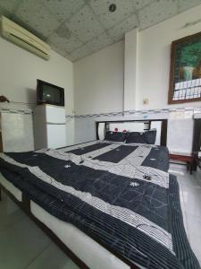 een groot bed in een kamer met een tv bij NHÀ NGHỈ BẾN TÀU in Rach Gia