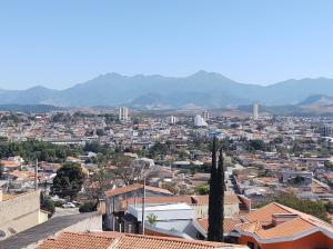 Una vista de una ciudad con montañas al fondo. en Apartamento mobiliado com vista exclusiva da Serra, en Cruzeiro