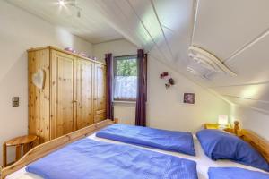 1 dormitorio con cama con sábanas azules y ventana en Ferienhaus Nina en Kirchheim
