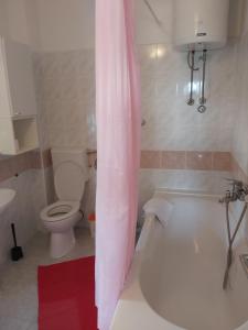 een badkamer met een wit bad en een toilet bij Apartman Helena in Gradac