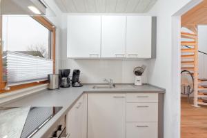 una cocina con armarios blancos y una ventana en Ferienhaus Nina, en Kirchheim