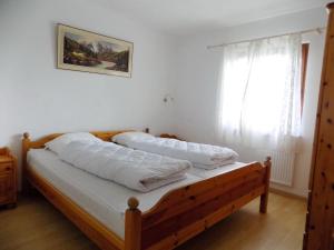 a bedroom with a bed with white sheets and a window at Ferienhaus Vera in Kirchheim