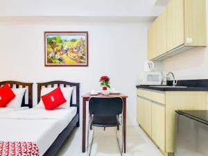 a room with a bed and a table and a kitchen at OYO 893 Dian Suites Makati in Manila