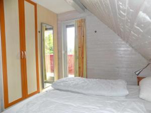 een wit bed in een kamer met een raam bij Ferienhaus Simone in Kirchheim