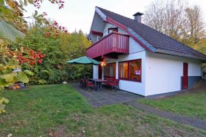une petite maison blanche avec une table et des chaises dans l'établissement Ferienhaus Simone, à Kirchheim