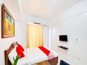 a hotel room with a bed and a television at OYO 893 Dian Suites Makati in Manila