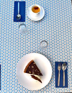 un morceau de gâteau sur une plaque blanche sur une table dans l'établissement Relais Des Villards, à Séez