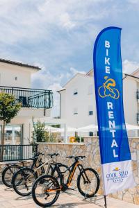 a group of bikes parked next to a stone wall at Cool Šilo Appartement Resort in Šilo