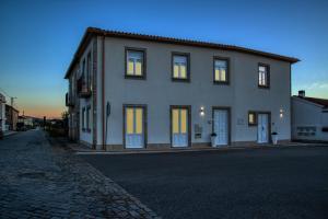 uma grande casa branca com as luzes acesas em Alojamento da Vila - Apartamentos em Valença