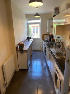 a large kitchen with a sink and a window at 35 mins to central London. 3 bedrooms. 2 bathrooms with garden in London