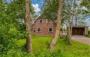 uma casa de tijolos no meio de um quintal com árvores em Nice Home In Niebll With Kitchen em Niebüll