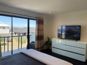 um quarto com uma televisão de ecrã plano numa cómoda em Waterside Holiday Home em Redcliffe