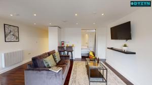 een woonkamer met een bank en een tv bij One Bed Apartment Newport - Garden - Parking - By DYZYN in Newport