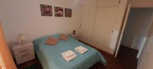 a small bedroom with a blue bed with two pillows at PRECIOSO dpto p/8, super céntrico estacionamiento gratis in Concordia