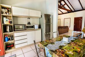 uma cozinha com uma mesa e um frigorífico em Casa Del Rey - cond. fechado Centro em Pirenópolis
