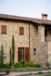 a brick house with wooden shutters on it at Hortus Natural Living in Todi
