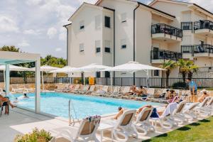 a swimming pool with lounge chairs and a hotel at Cool Šilo Appartement Resort in Šilo