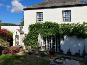 a white house with a garden and an umbrella at Little Silver in Great Torrington