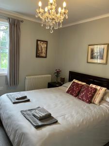 a bedroom with a large white bed with a chandelier at Little Silver in Great Torrington