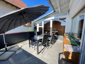 patio con tavolo, sedie e ombrellone di Appartement Martha a Laufenburg