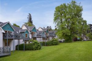 uma casa grande com um quintal verde em Wyndham Duchally Country Estate em Auchterarder