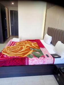 a bed with a blanket on top of it at Hotel The Grand Tilak By WB Inn