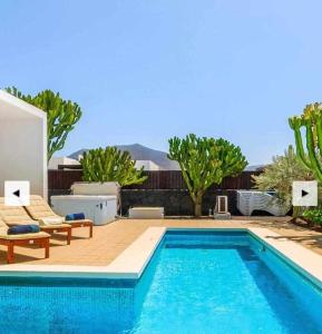 a swimming pool in the middle of a yard with trees at Jacks Place Villa PlayaBlanca Pool Spa in Playa Blanca