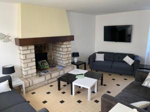 - un salon avec un canapé et une cheminée dans l'établissement La Barberie à Saint-Marcouf, à Saint-Marcouf