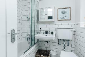 a white bathroom with a sink and a shower at The Dragonfly - Central 2 bedroom house in Henley on Thames