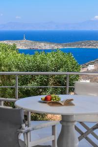 a table and chairs with a book and fruit on it at Syros Luxury Living in Rózia