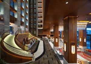 a lobby of a hotel with a spiral staircase at Mövenpick Hotel Istanbul Asia Airport in Istanbul
