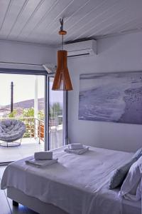 a bedroom with a bed and a view of the ocean at Syros Luxury Living in Rózia