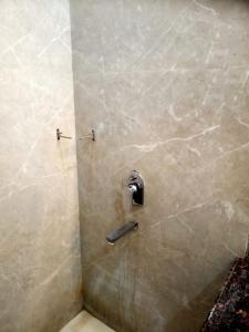 a shower stall with a toilet paper dispenser on a wall at Hotel The Grand Tilak By WB Inn