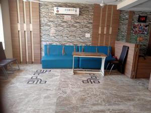 a blue couch and a table in a room at Hotel The Grand Tilak By WB Inn