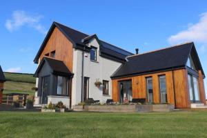 a large white house with a black roof at The Cottage - spacious getaway with stunning views in Auchenblae