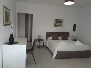 a bedroom with a bed and a table with a chair at Cala Caterina Rooms in Villasimius