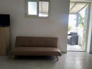 a living room with a couch and a window at Cala Caterina Rooms in Villasimius