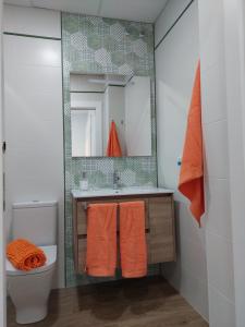 a bathroom with a sink and a toilet and a mirror at Orange Suite by Alhaurín Loft City Center in Alhaurín de la Torre