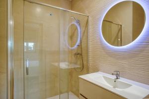 un bagno con doccia, lavandino e specchio di Flor de Valença Guest House a Valença Altre 37 foto