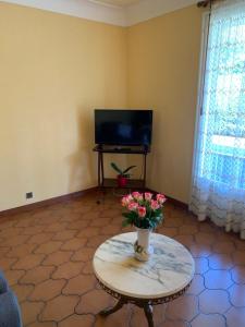 salon ze stołem i wazą kwiatów w obiekcie A louer appartement dans une maison w mieście Arcangues