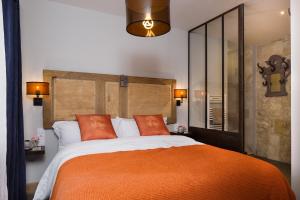 ein Schlafzimmer mit einem großen Bett mit einer orangefarbenen Decke in der Unterkunft Château de Candes - Art & Spa in Candes-Saint-Martin