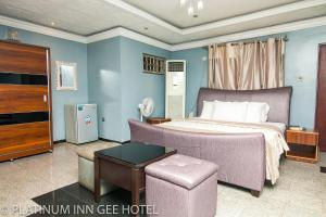 a bedroom with a king sized bed and a living room at Platinum Inn Gee Hotel in Suru Lere