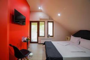 1 dormitorio con cama y pared roja en Elysium Gallery Hotel, en Ereván