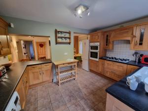 cocina grande con armarios y electrodomésticos de madera en Kingsfield House by Cliftonvalley Apartments en Bristol