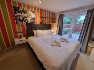 a bedroom with a large bed with towels on it at Kingsfield House by Cliftonvalley Apartments in Bristol