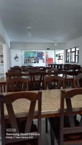 a dining room with wooden tables and chairs at Hotel Sol A Sol in Cananéia